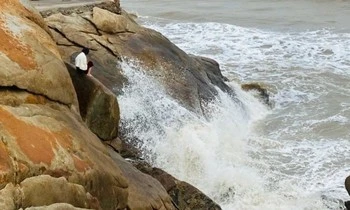 Người phụ nữ đứng trên mỏm đá, định gieo mình xuống biển Sầm Sơn-cover-img